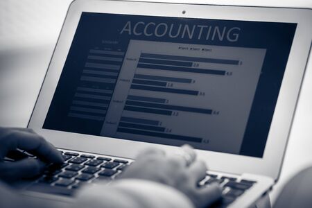 Asian business woman reviewing data in financial charts and graphs. Accountingの写真素材