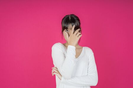 young asian woman protects herself by exposing her hand in front of herの写真素材