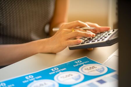 Asian business woman reviewing data in financial charts and graphs. Accountingの写真素材