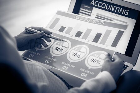 Asian business woman reviewing data in financial charts and graphs. Accountingの写真素材
