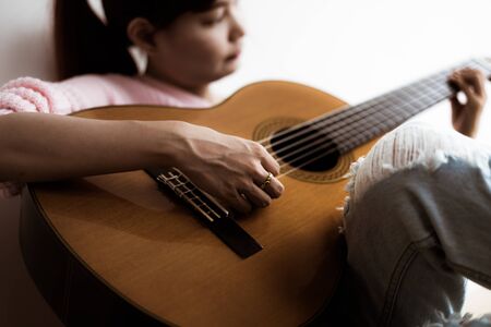 A beautiful asian woman playing acoustic guitarの写真素材
