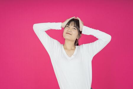 asian young casual style woman portrait isolated over pink background.の写真素材