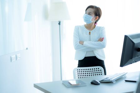 Asian woman using the medical face mask in officeの写真素材