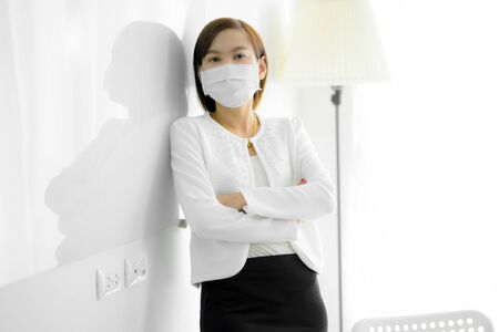 Asian woman using the medical face mask in officeの写真素材