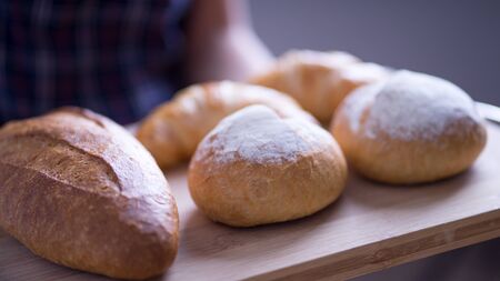 Woman Hands Hold Wooden Tray Present Fresh Baked Bakeryの写真素材