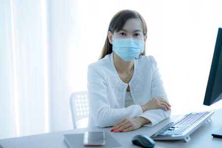 Asian woman using the medical face mask in officeの写真素材