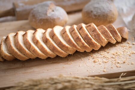 Different fresh bread on wooden tableの写真素材