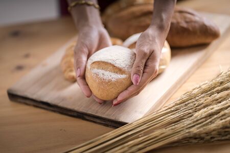 Woman Hands Hold Wooden Tray Present Fresh Baked Bakeryの写真素材