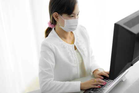 Asian woman using the medical face mask in officeの写真素材
