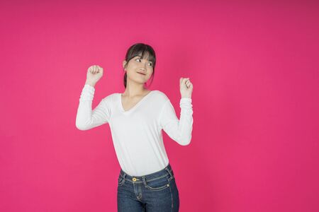 I won. Winning success happy woman celebrating being a winner. Dynamic image of caucasian female model on pink studio background. Victory, delight concept. Human facial emotions concept. Trendy colorsの写真素材