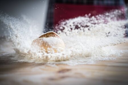 Fresh bread on the kitchen table. Fresh bread on table close-up in flour placer. The healthy eating...