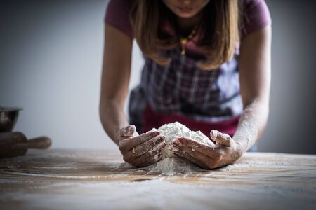 Making dough by female hands at bakery