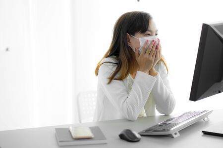 Asian woman using the medical face mask in officeの写真素材