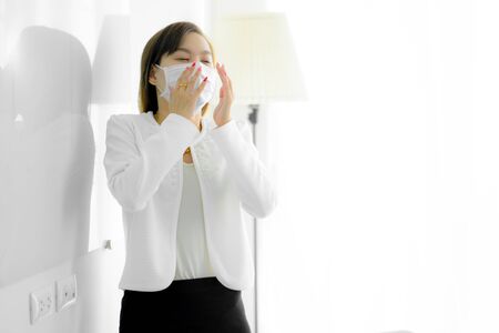 Asian woman using the medical face mask in officeの写真素材