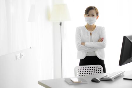 Asian woman using the medical face mask in officeの写真素材