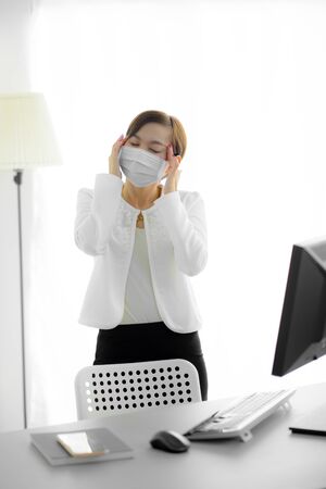 Asian woman using the medical face mask in officeの写真素材