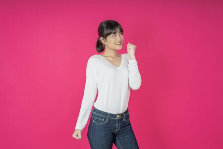 I won. Winning success happy woman celebrating being a winner. Dynamic image of caucasian female model on pink studio background. Victory, delight concept. Human facial emotions concept. Trendy colorsの写真素材