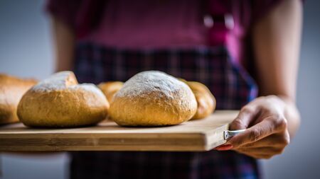 Woman Hands Hold Wooden Tray Present Fresh Baked Bakeryの写真素材