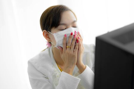 Asian woman using the medical face mask in officeの写真素材