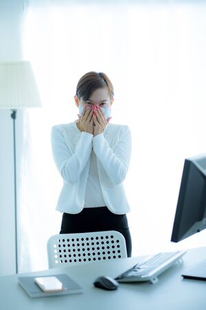 Asian woman using the medical face mask in officeの写真素材