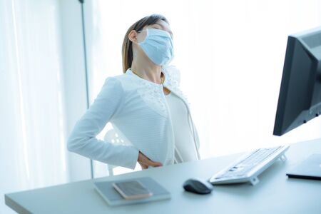 Asian woman with back pain in officeの写真素材