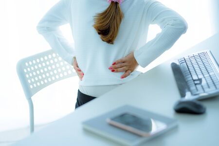 Asian woman with back pain in officeの写真素材