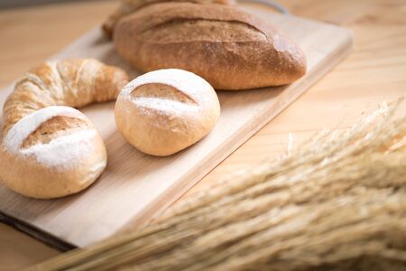 Different fresh bread on wooden tableの写真素材