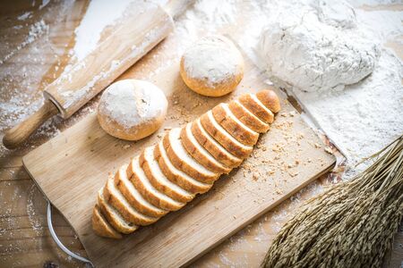 Different fresh bread on wooden tableの写真素材