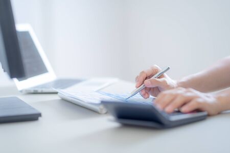 Asian business woman reviewing data in financial charts and graphs. Accountingの写真素材