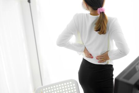 Asian woman with back pain in officeの写真素材