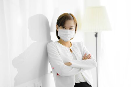 Asian woman using the medical face mask in officeの写真素材