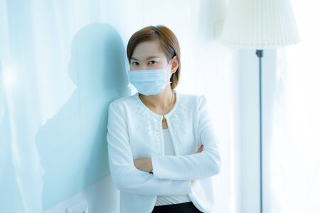 Asian woman using the medical face mask in officeの写真素材