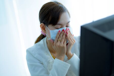 Asian woman using the medical face mask in officeの写真素材