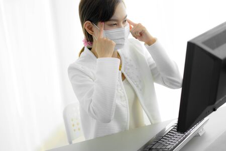 Asian woman using the medical face mask in officeの写真素材