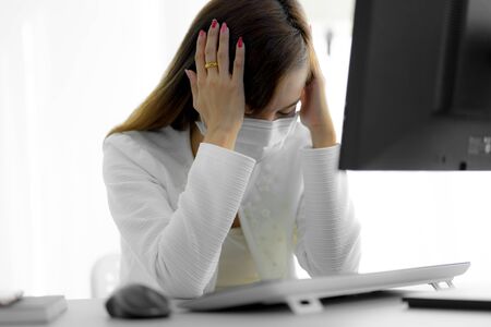 Asian woman using the medical face mask in officeの写真素材