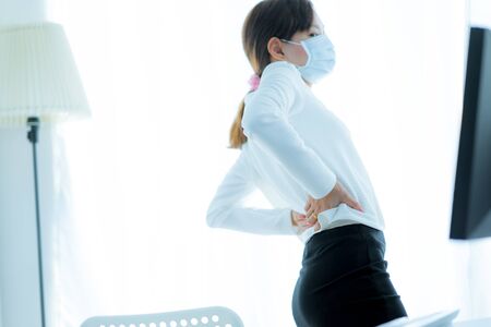 Asian woman with back pain in officeの写真素材