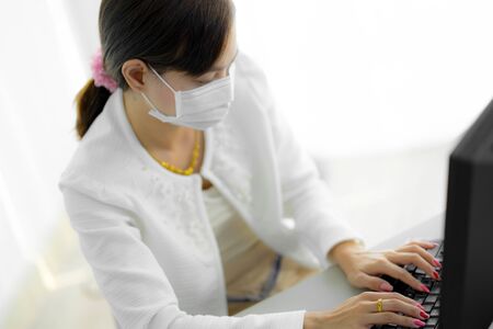 Asian woman using the medical face mask in officeの写真素材