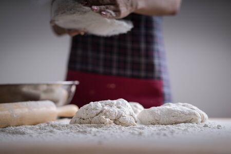 Making dough by female hands at bakeryの写真素材