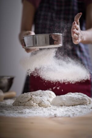Making dough by female hands at bakeryの写真素材