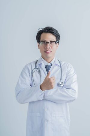 healthcare and medical concept - young male doctor with stethoscope. Asian male modelの写真素材