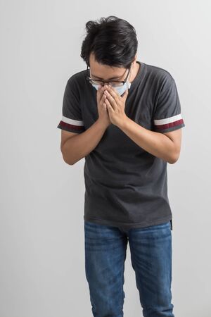 Portrait of young man with medicine health care mask against white gray background. Asian peopleの写真素材