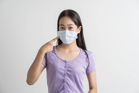 Close up portrait of young woman with medicine health care mask against white white background. CoronaVirus, Covid-19. Asian peopleの写真素材