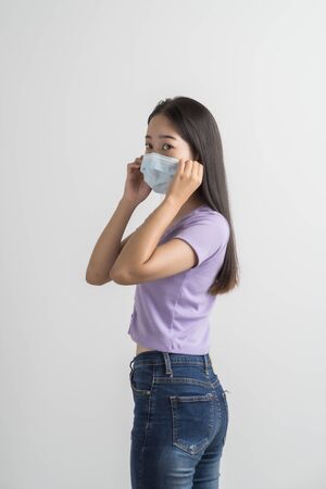 Close up portrait of young woman with medicine health care mask against white white background. CoronaVirus, Covid-19. Asian peopleの写真素材