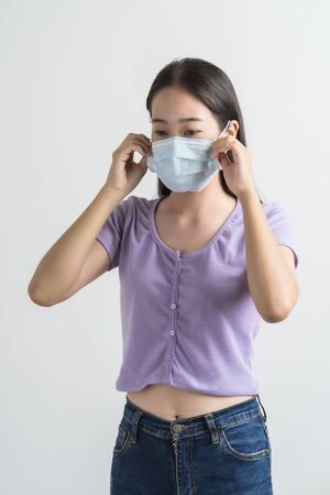 Close up portrait of young woman with medicine health care mask against white white background. CoronaVirus, Covid-19. Asian peopleの写真素材