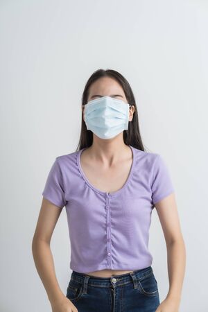 Close up portrait of young woman with medicine health care mask against white white background. CoronaVirus, Covid-19. Asian peopleの写真素材