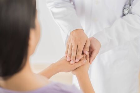 male doctor comforting patient at consulting room. Asian peopleの写真素材