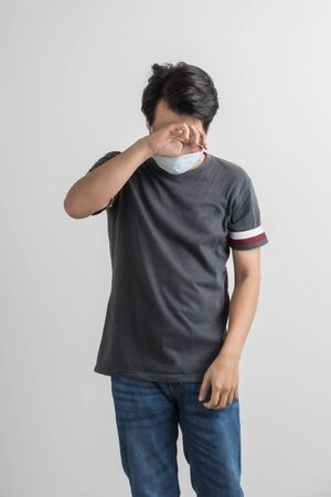 Portrait of young man with medicine health care mask against white gray background. Asian peopleの写真素材