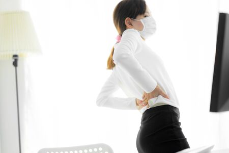 Asian woman with back pain in officeの写真素材
