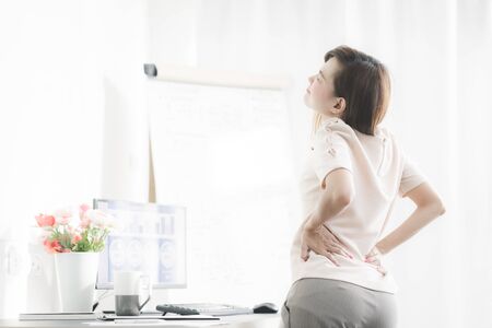 Business woman with back pain in office. Asian people. Work at home conceptの写真素材