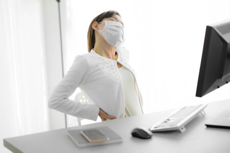 Asian woman with back pain in officeの写真素材